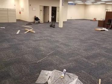 Adma Biologics large open area with finished carpet tile installation in progress