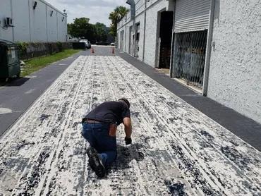 Tequesta Point Condominium installer seaming carpet in driveway