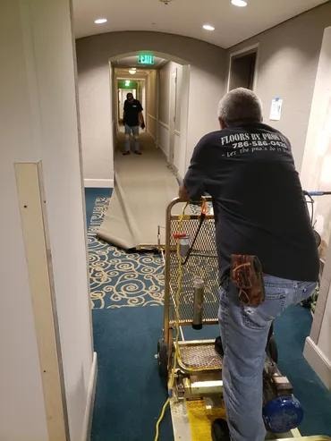 Tequesta Point Condominium Floors By Pros crew installing carpet in hallway